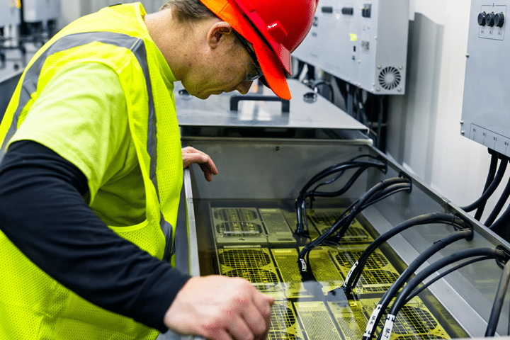 Worker looks into immersion cooling tank